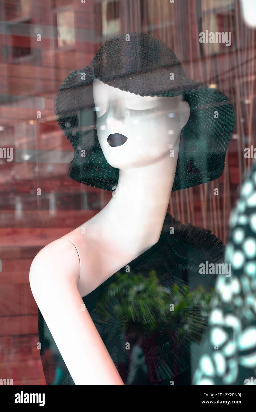 Belgrade, Serbie - 3 avril 2024 : poupée mode mannequin portant un chapeau de soleil en crochet noir avec des reflets dans la vitrine du magasin Max Mara Banque D'Images