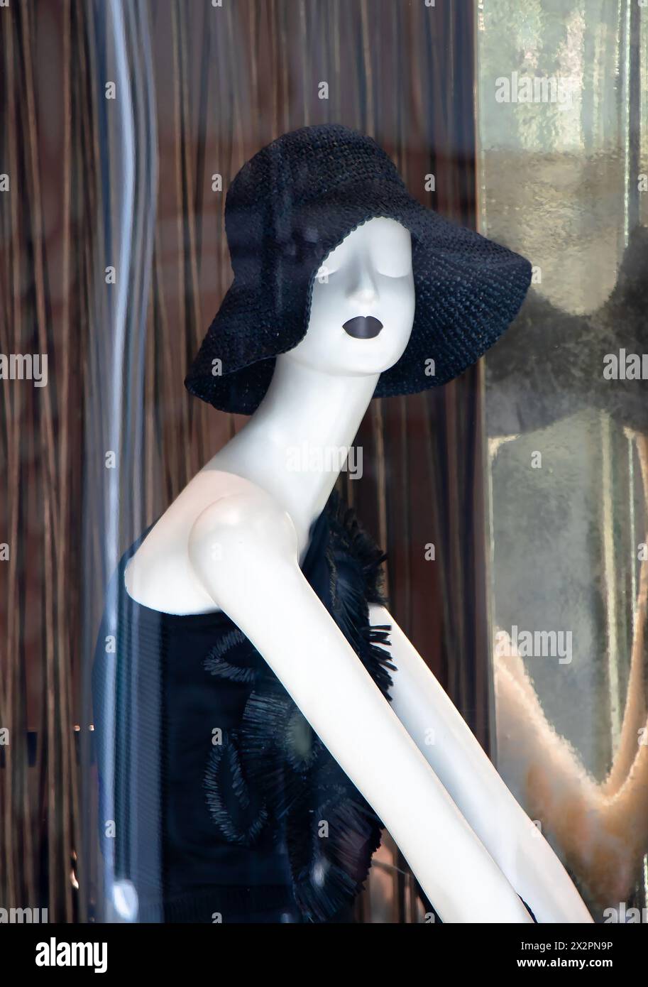Belgrade, Serbie - 3 avril 2024 : poupée mode mannequin portant un chapeau de soleil en crochet noir avec des reflets dans la vitrine du magasin Max Mara Banque D'Images