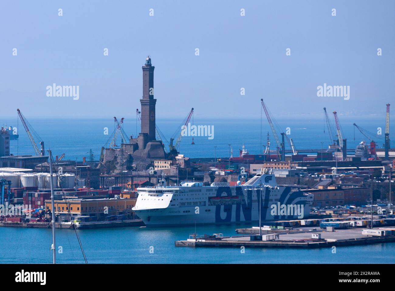 Gênes, Italie - mars 29 2019 : paquebot amarré au port avec derrière, le phare de Gênes. Banque D'Images