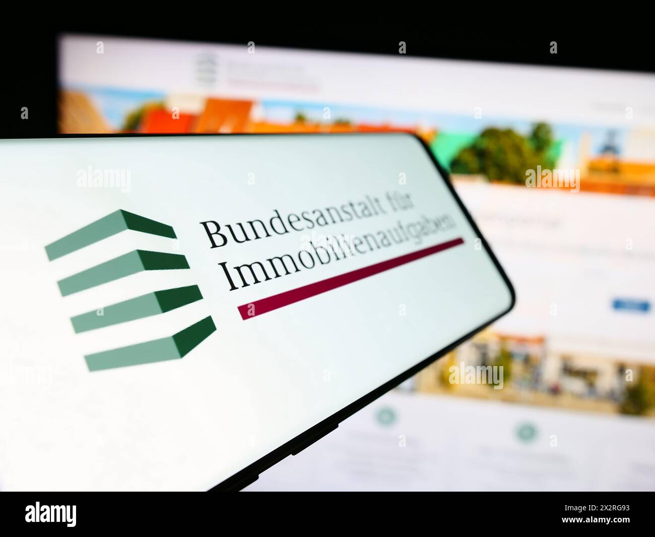 Téléphone portable avec le logo de l'agence allemande Bundesanstalt für Immobilienaufgaben (BIMA) en face du site Web de l'entreprise. Focus à gauche de l'écran du téléphone. Banque D'Images