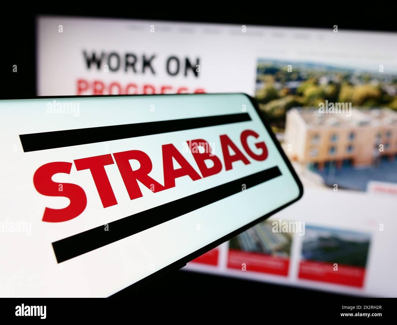 Téléphone portable avec le logo de l'entreprise de construction autrichienne Strabag se en face du site Web de l'entreprise. Mettez l'accent sur le centre-gauche de l'écran du téléphone. Banque D'Images