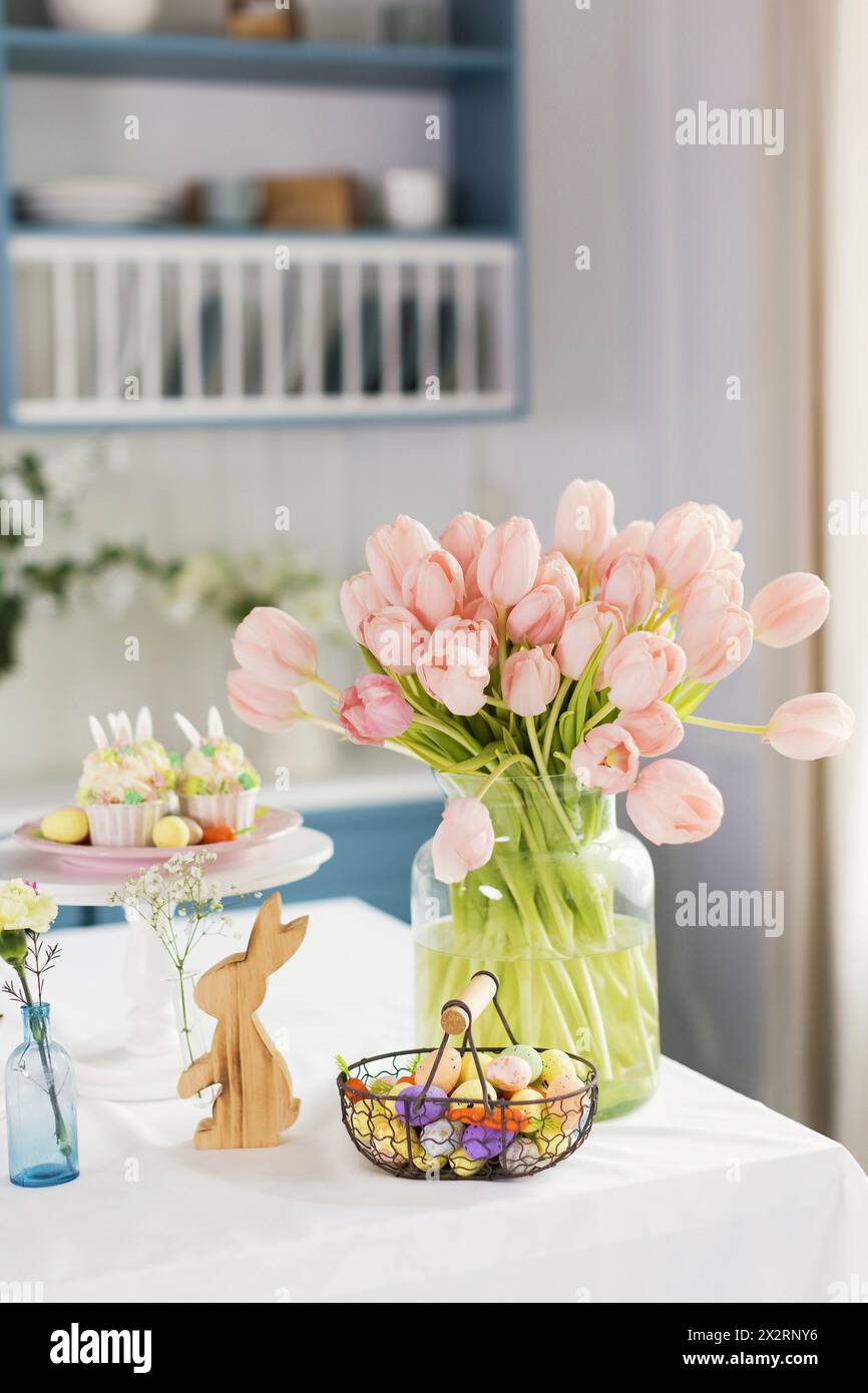Décorations de Pâques et tulipes couleur pêche sur table à la maison Banque D'Images