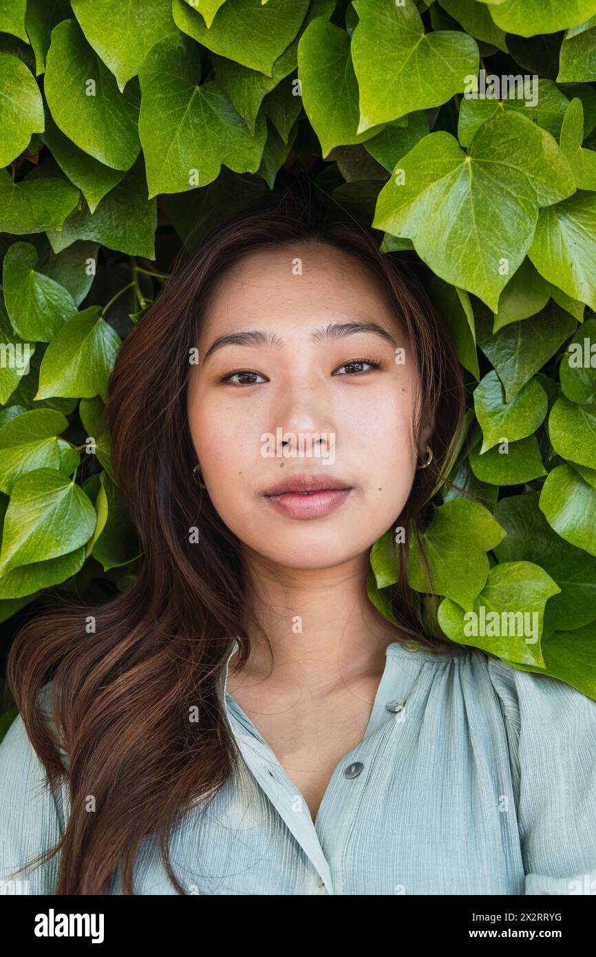 Jeune femme au milieu d'une haie verte Banque D'Images