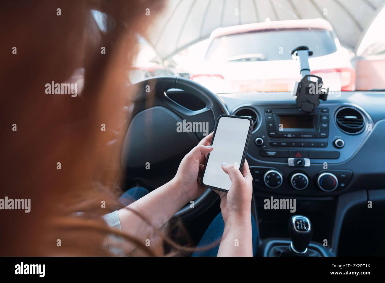Jeune femme utilisant un smartphone en voiture Banque D'Images