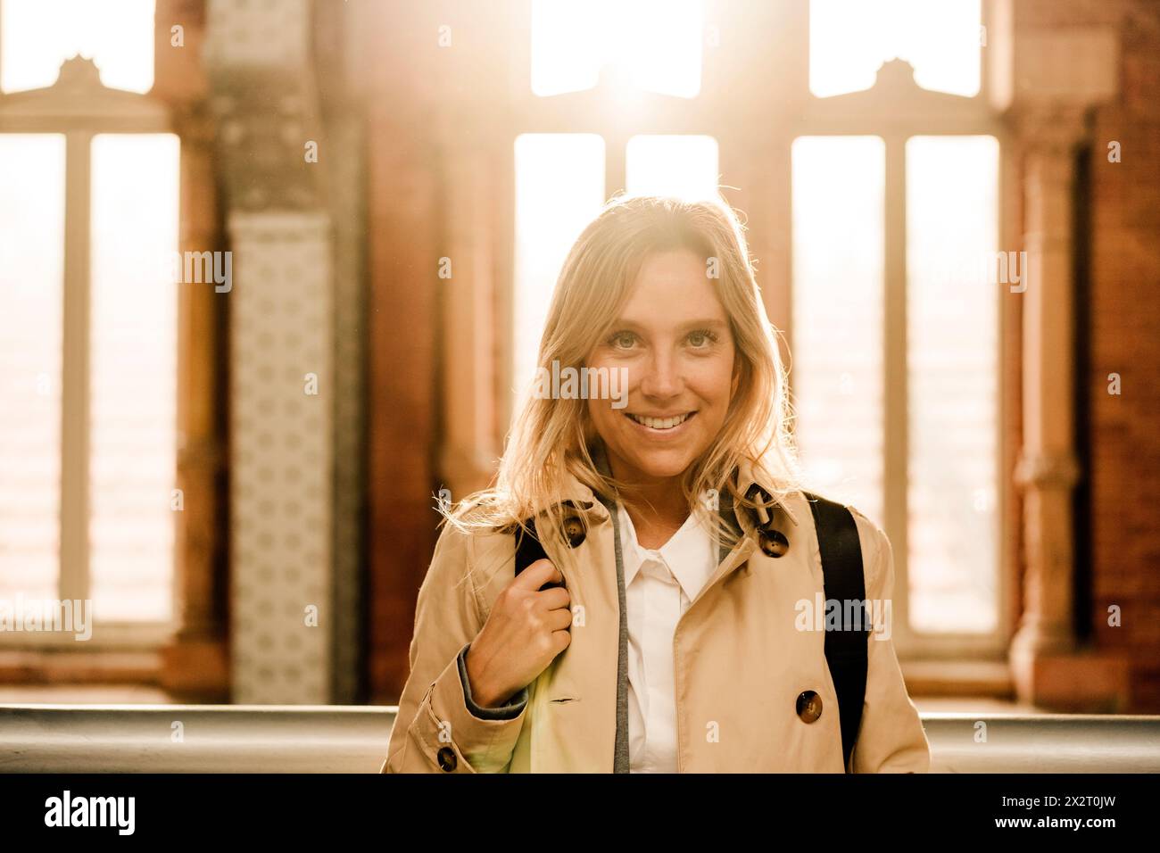 Femme souriante avec les cheveux mis en évidence à la station Banque D'Images