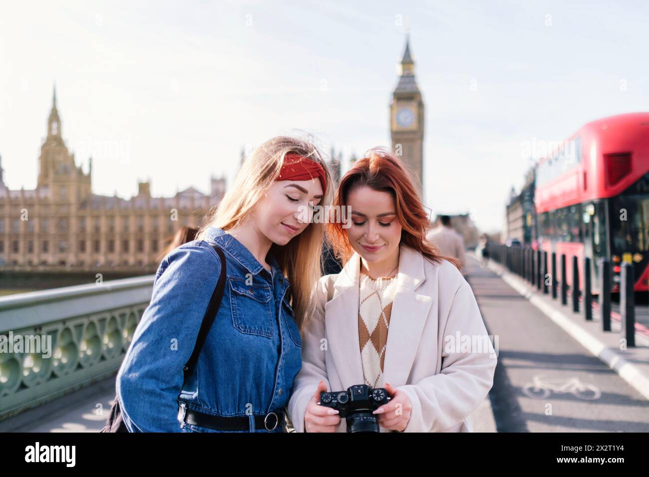 Amis souriants debout avec la caméra dans la ville de Londres, Angleterre Banque D'Images