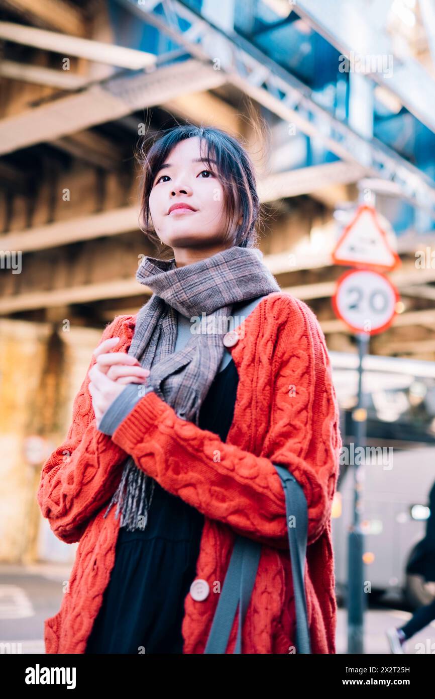 Belle jeune femme debout avec les mains serrées dans la rue Banque D'Images