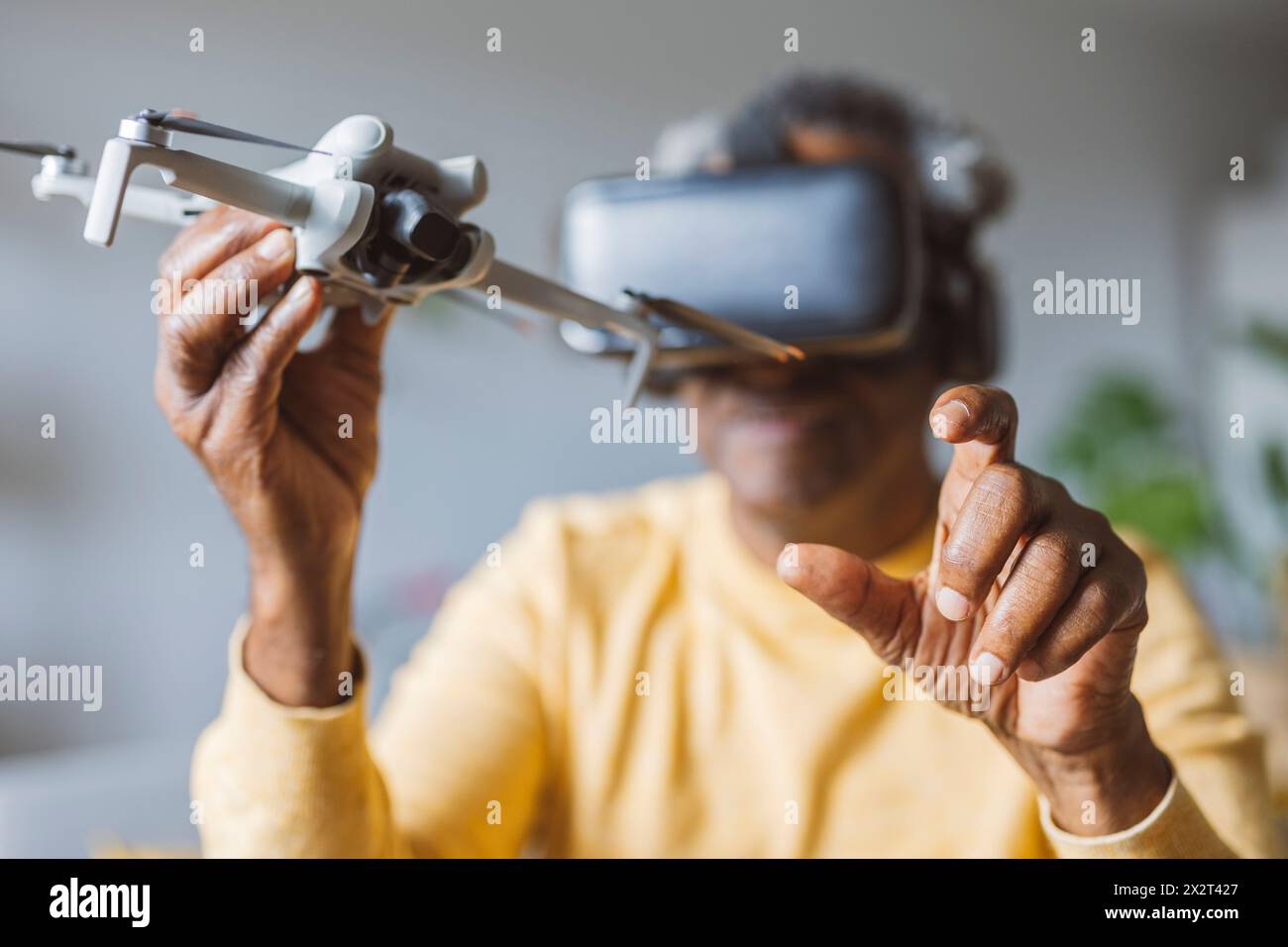 Homme senior dans des lunettes VR apprenant à opérer un drone Banque D'Images