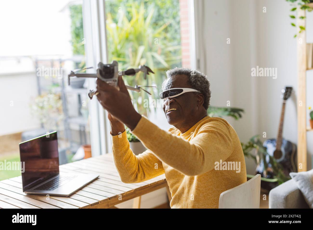 Homme senior portant des lunettes intelligentes apprenant à opérer un drone Banque D'Images