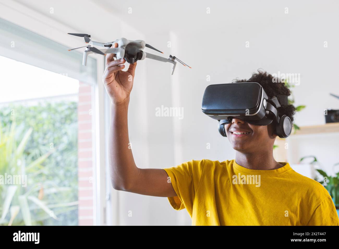 Adolescent dans des lunettes VR apprenant à opérer un drone Banque D'Images