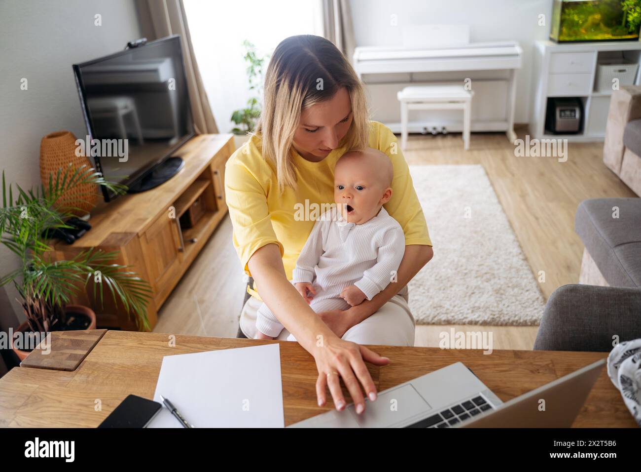Femme d'affaires utilisant un ordinateur portable assis avec son fils à table Banque D'Images