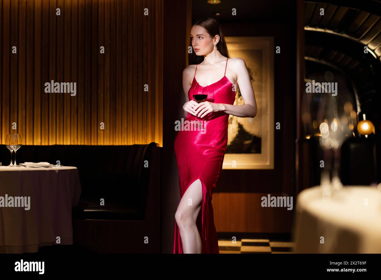 Femme glamour tenant un verre de vin au club cher Banque D'Images