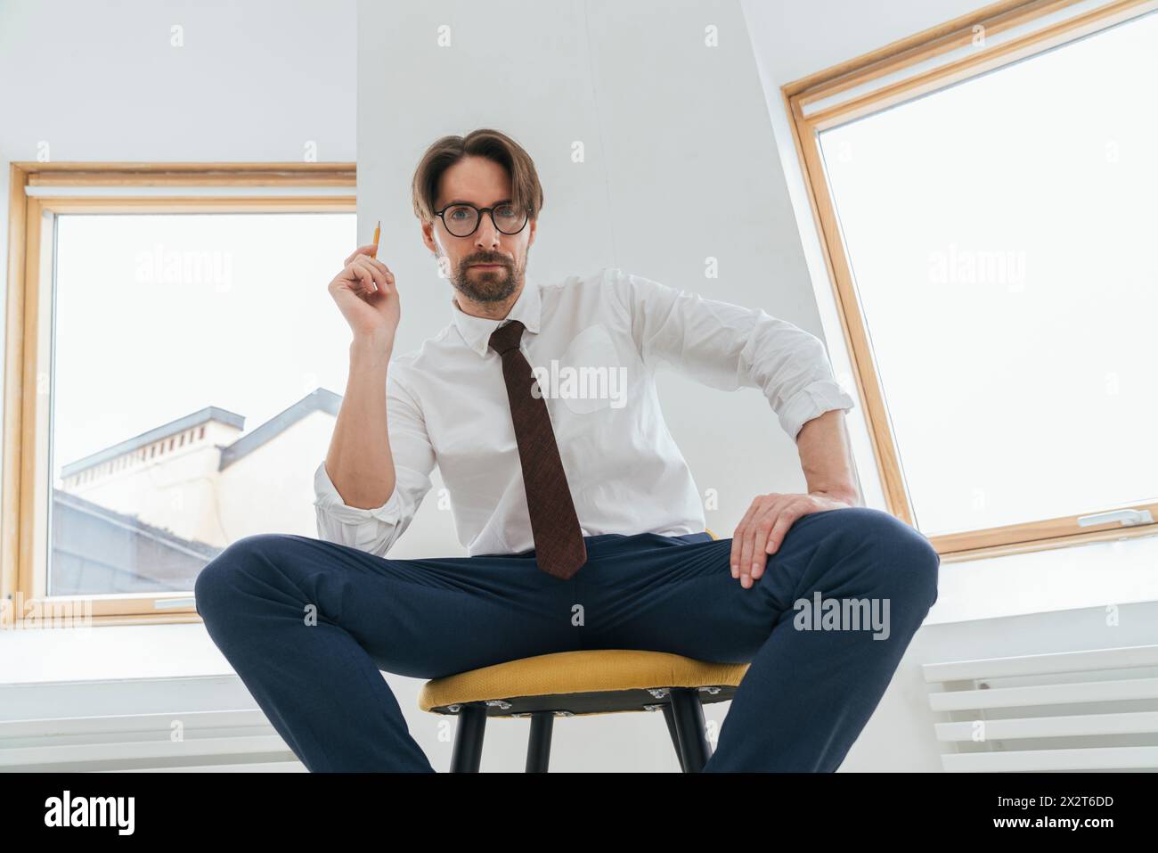 Homme d'affaires confiant assis sur une chaise au bureau Banque D'Images