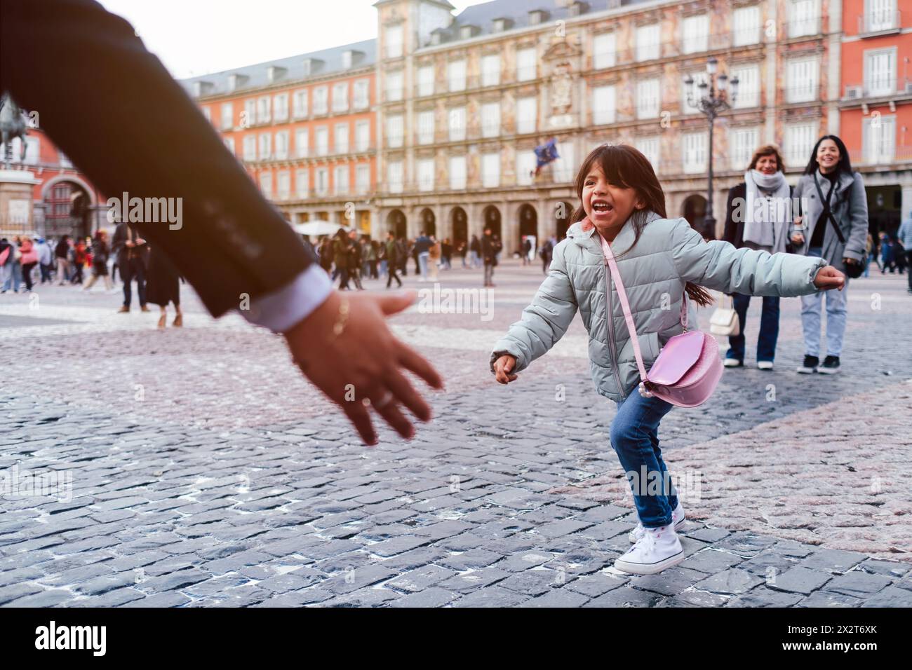 Jeune fille joyeuse courant vers son père sur la place de la ville Banque D'Images