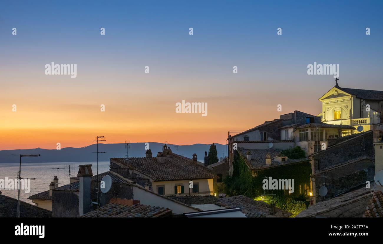 Italie, Latium, Anguillara Sabazia, toits de maisons surplombant le lac Bracciano au crépuscule Banque D'Images