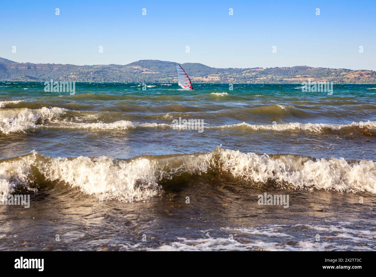 Italie, Latium, Anguillara Sabazia, vagues sur le lac Bracciano avec planche à voile en arrière-plan Banque D'Images