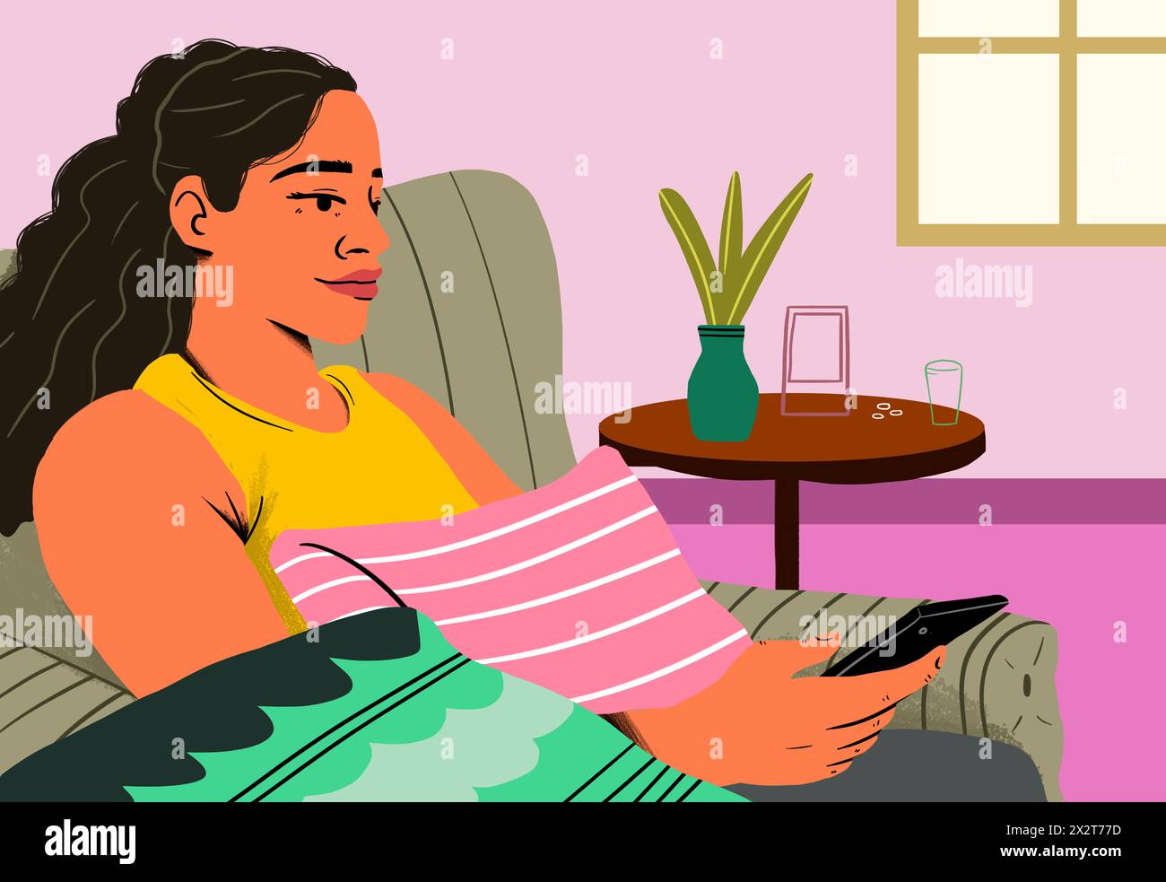 Femme utilisant un smartphone assis sur un canapé à la maison Banque D'Images