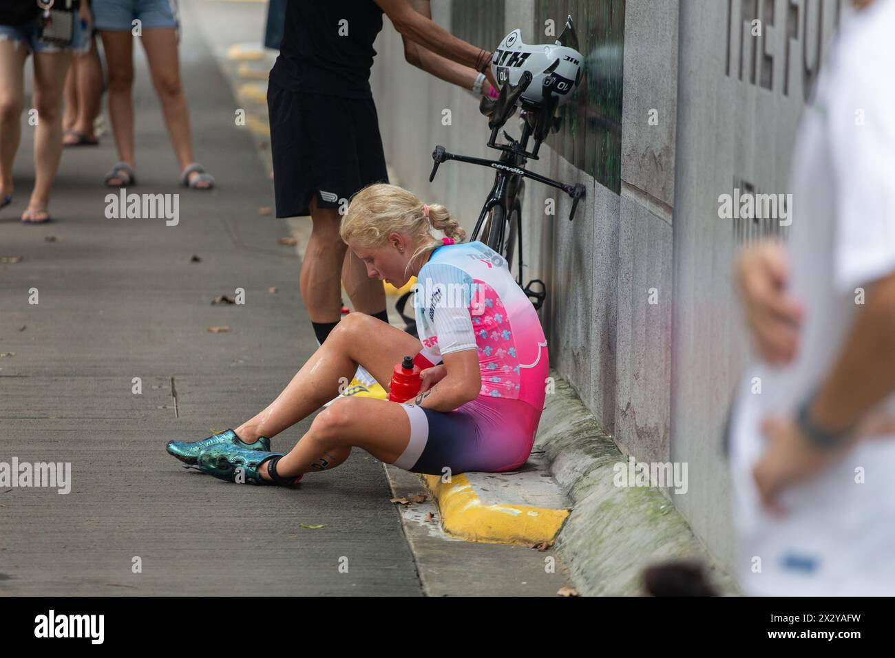 13 avril 2024. Une athlétique féminine prend sa retraite pendant la course de vélo lors de l'épreuve de triathlon T100. Le temps chaud a fait encore plus de ravages physiques. Singapour. Banque D'Images