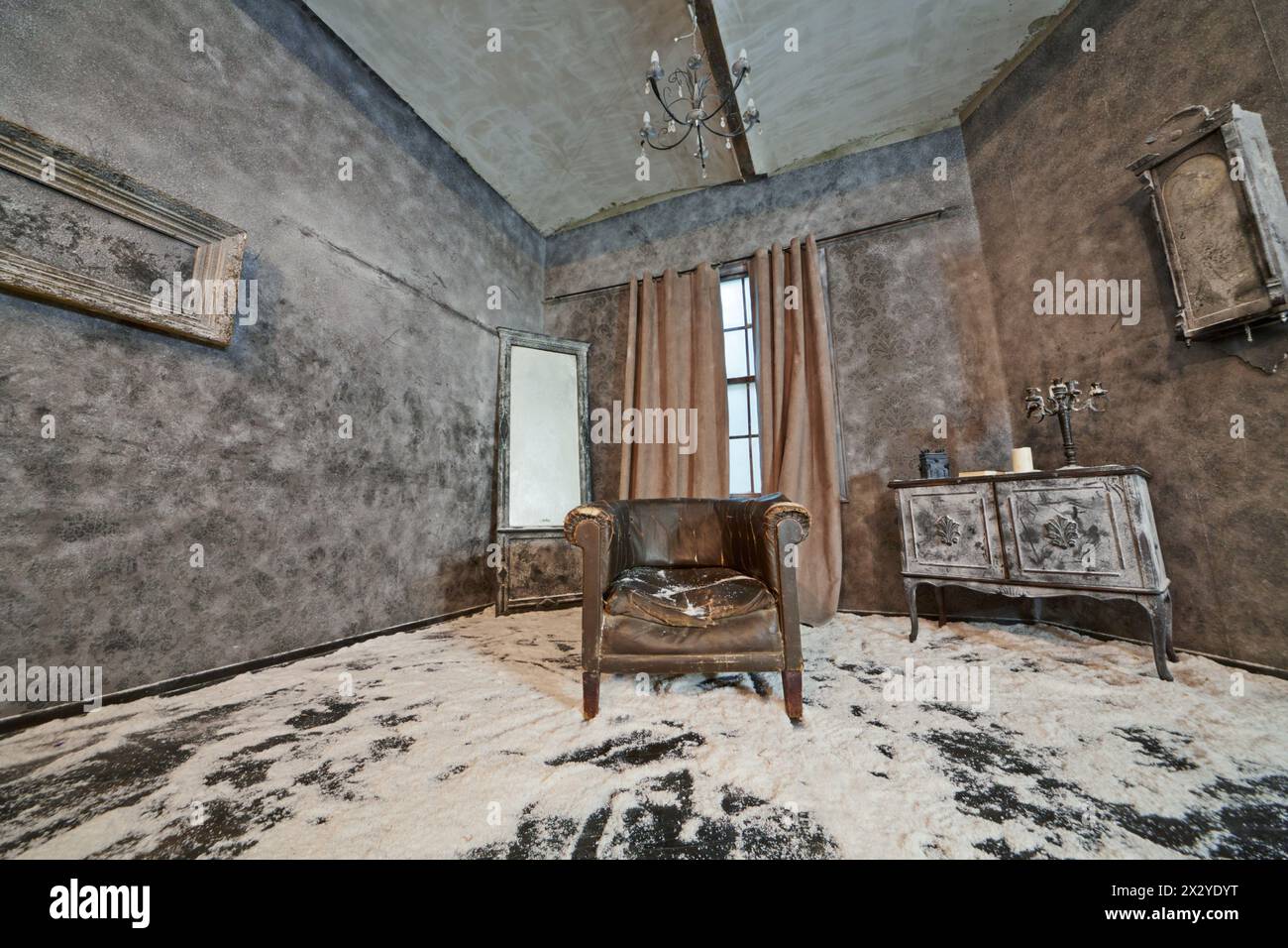 Décoration de chambre abandonnée poudrée de neige avec vieux fauteuil affaissé éraflé dans le studio public à louer Banque D'Images