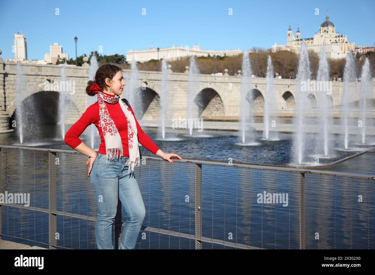 Jeune femme heureuse se tient près du pont de Ségovie à Madrid, Espagne. Banque D'Images