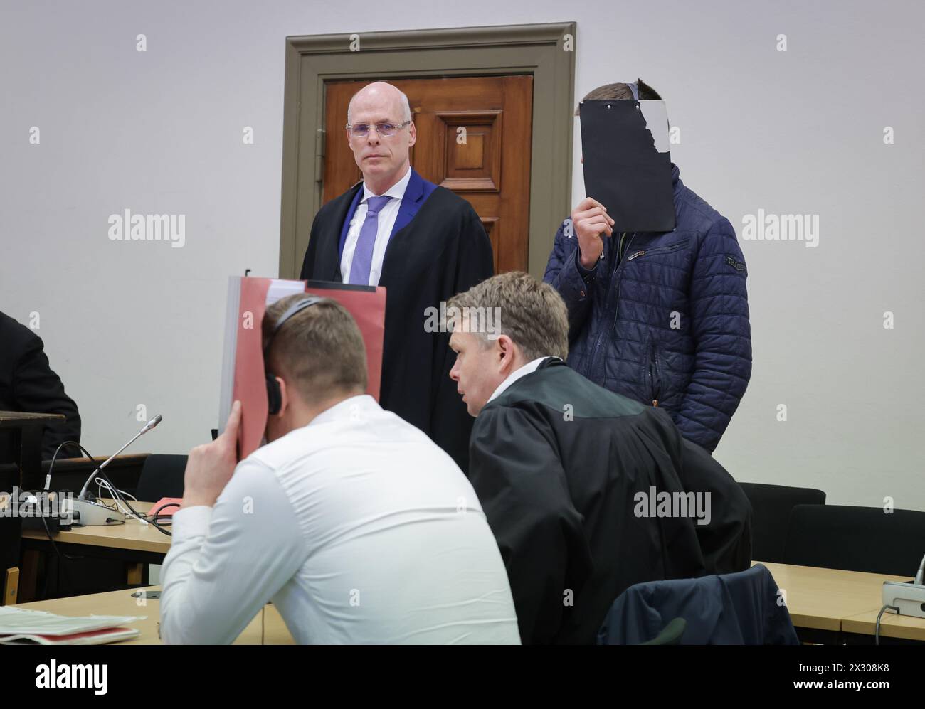 Hambourg, Allemagne. 24 avril 2024. Les accusés et leurs avocats Joachim Lauenburg (2e à partir de la gauche) et Dennis Dördrechter (2e à partir de la droite) siègent dans la salle d'audience avant le début de la journée du procès dans le bâtiment de la justice pénale. Comme la Cour fédérale de justice (BGH) a partiellement annulé le verdict contre les deux accusés, l'affaire, une agression violente contre un homme dans l'appartement d'un mécanicien de Hambourg en été 2021, doit être rejugée. Crédit : Christian Charisius/dpa/Alamy Live News Banque D'Images