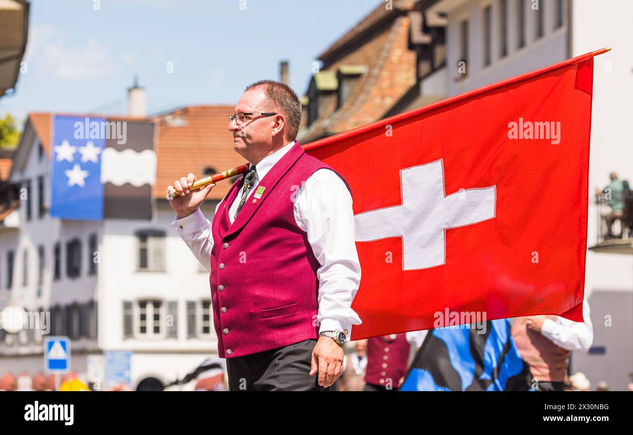 Ein Mann in traditioneller Schweizer Tracht steht mit einer Schweizer Fahne während dem Festumzug des Jodelfests in der Bad Zurzacher Altstadt. (Mauvais Z Banque D'Images