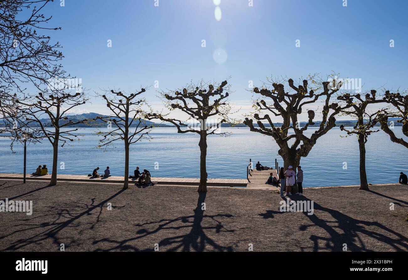 AM Ufer des Zugersee geniessen die Menschen die wärmenden Sonnenstrahlen im Frühling. (Zoug, Schweiz, 18.04.2022) Banque D'Images