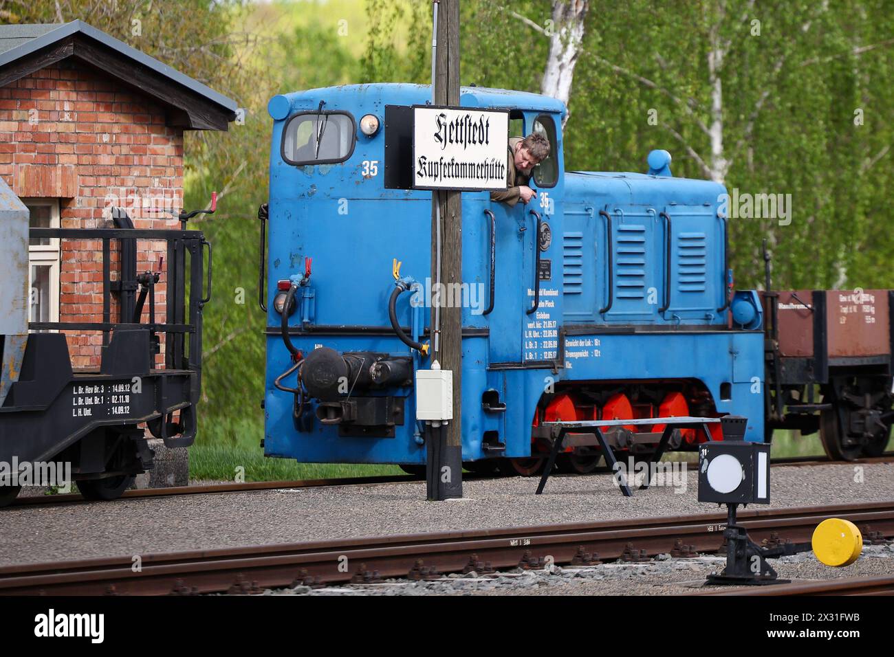 Hettstedt, Allemagne. 18 avril 2024. Un membre de l'association Mansfelder Bergwerksbahn pivote des wagons de marchandises avec une locomotive diesel à la gare de Kupferkammerhütte. Le plus ancien chemin de fer à voie étroite opérationnel en Allemagne est également exploité comme un chemin de fer musée à vapeur sur une partie de l'ancien vaste réseau de chemins de fer miniers dans la région de Mansfeld. Crédit : Jan Woitas/dpa/Alamy Live News Banque D'Images