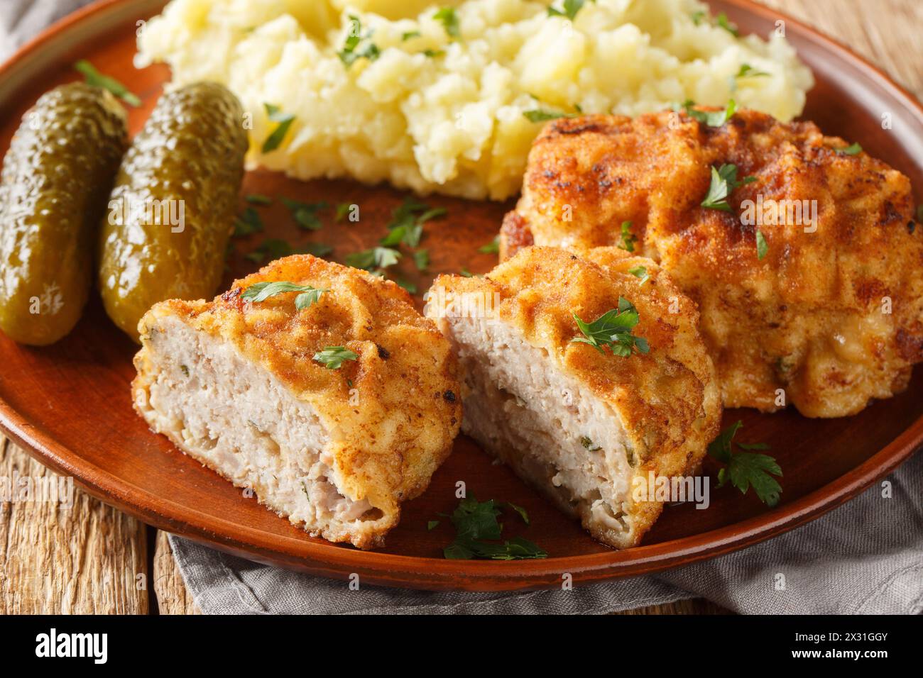 Boulette de porc tchèque Holandsky rizek au fromage, panée, servie avec purée de pommes de terre et gros plan mariné dans une assiette sur la table. Horizontal Banque D'Images