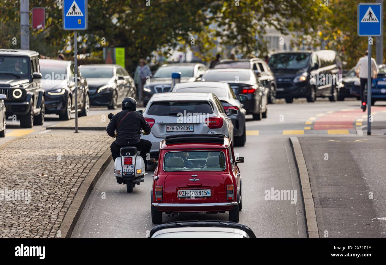 VOR einem Fussgängerstreifen in der Stadt Zürich staut sich der Verkehr. Eine Frau überquert den Fussgängerstreifen. (Zürich, Schweiz, 29.10.2022) Banque D'Images