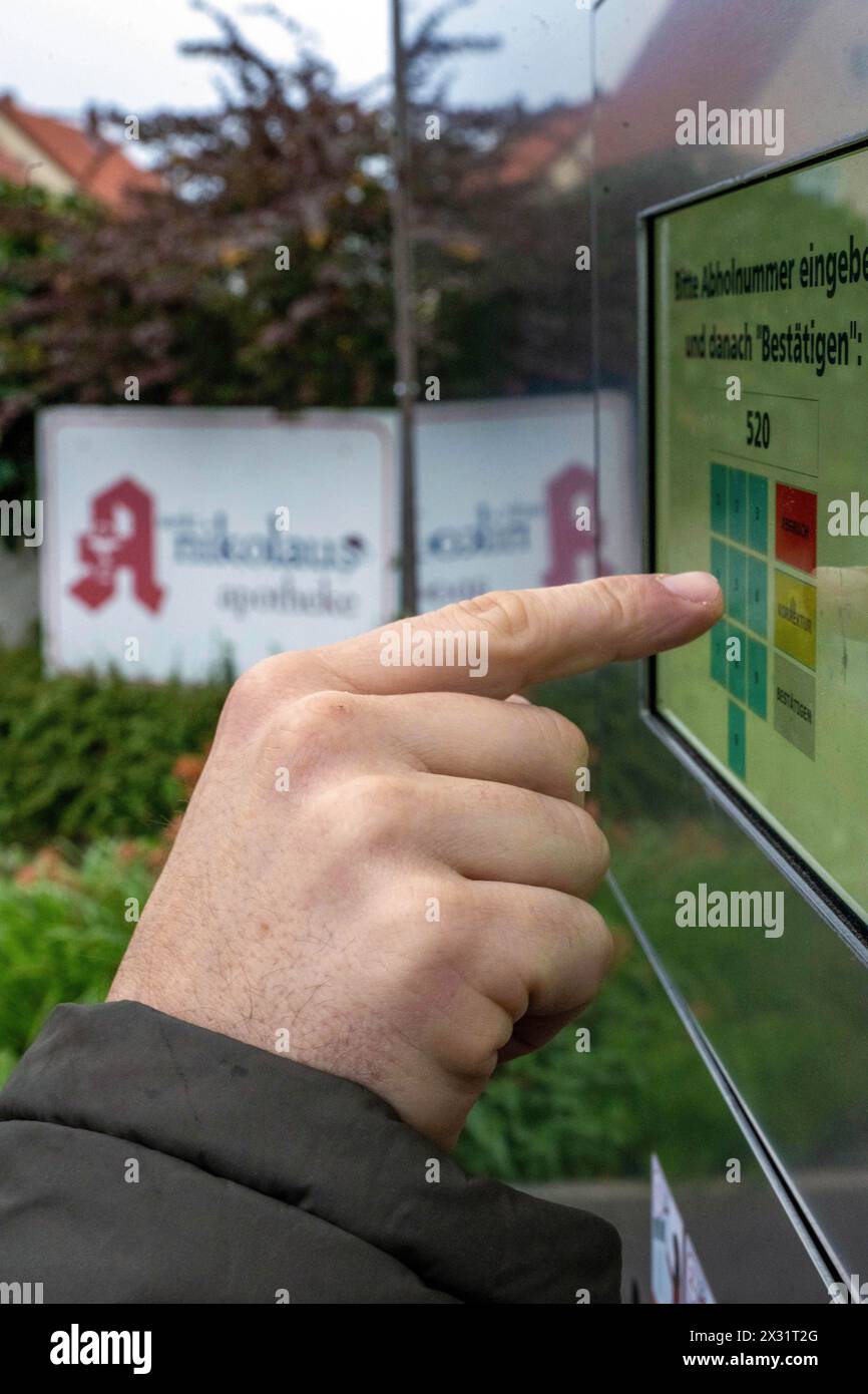 SYMBOL - 24 avril 2024, Bavière, Breitengüßbach : un homme tape un code numérique dans la machine de ramassage à l'extérieur d'une pharmacie pour récupérer les médicaments précommandés en dehors des heures d'ouverture. De plus en plus de pharmacies se tournent vers l’automatisation. Photo : Pia Bayer/dpa Banque D'Images