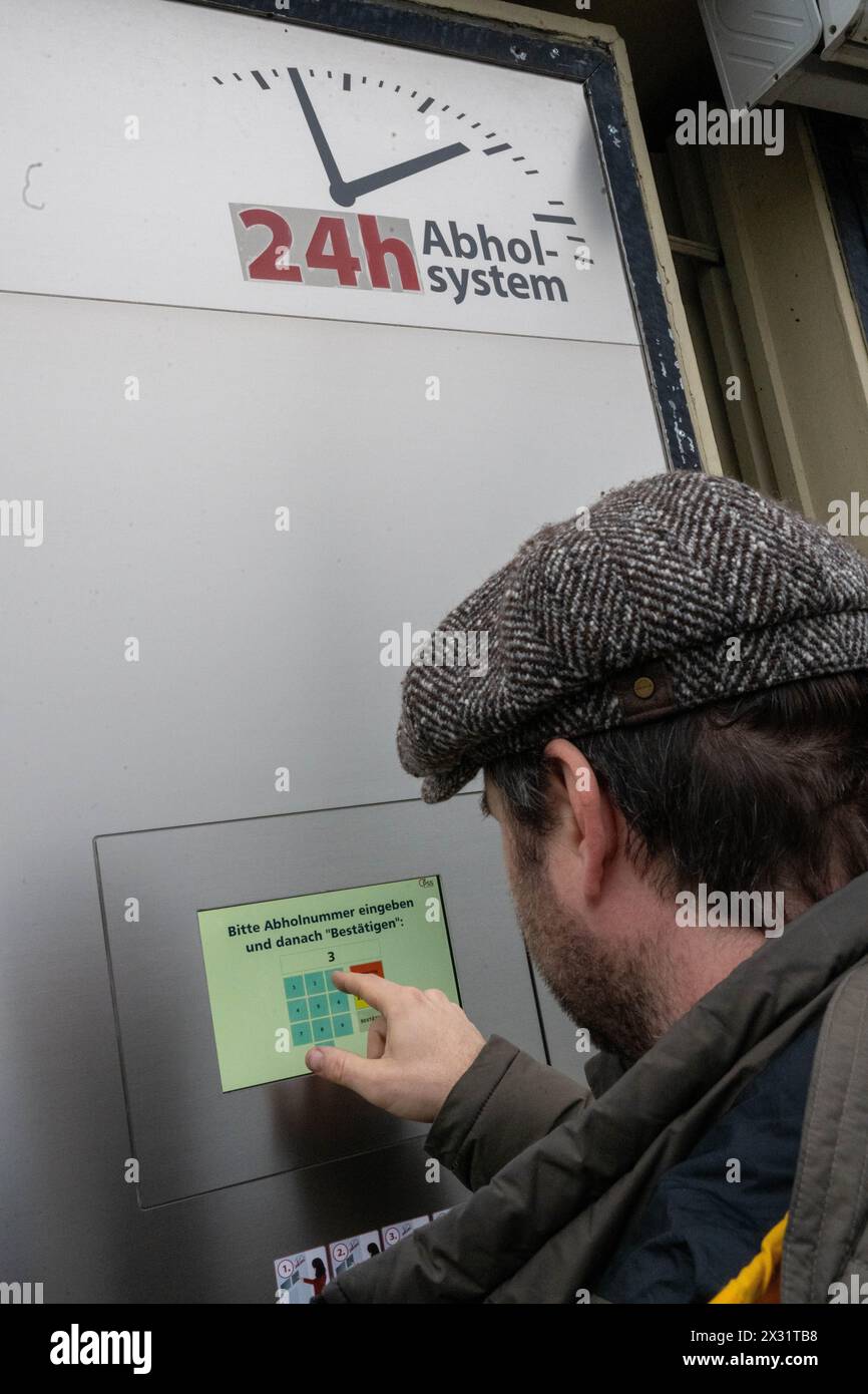 SYMBOL - 24 avril 2024, Bavière, Breitengüßbach : un homme tape un code numérique dans la machine de ramassage à l'extérieur d'une pharmacie pour récupérer les médicaments précommandés en dehors des heures d'ouverture. De plus en plus de pharmacies se tournent vers l’automatisation. Photo : Pia Bayer/dpa Banque D'Images