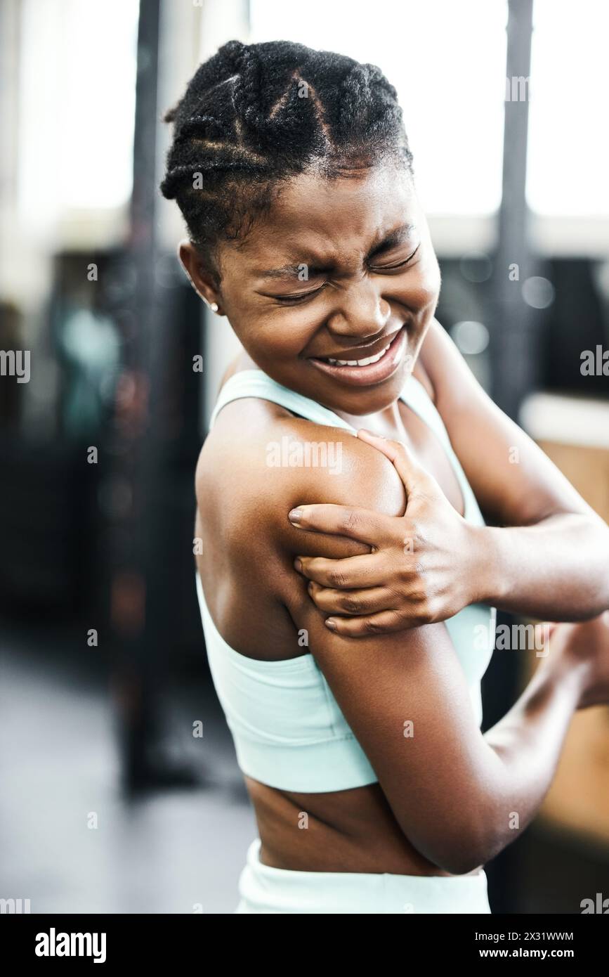 Femme personne, épaule et blessure de l'entraînement au gymnase avec accident ou douleur musculaire pour la forme physique. Fit, femme noire et bras de massage pour le médical Banque D'Images