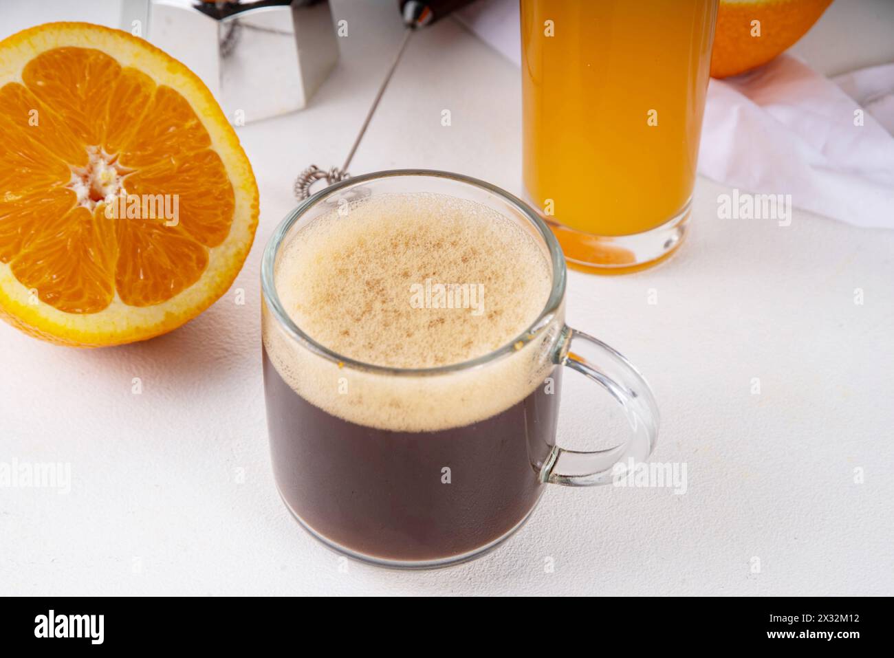 Boisson de café d'été CapuOrange, café noir avec jus d'orange fouetté, sur espace de copie de table blanche Banque D'Images