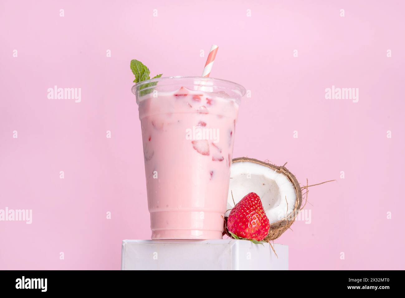 Milk-shake à la fraise et à la noix de coco, cocktail crémeux congelé avec lait de coco et fraises fouettées en tranches Banque D'Images