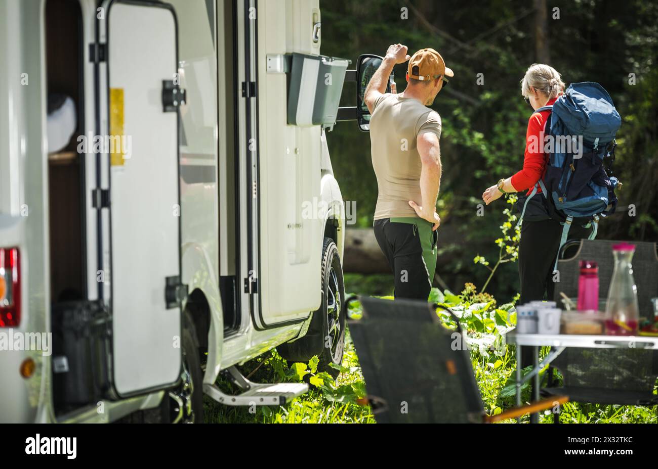 Couples caucasiens et leur camping-car de classe C. Vacances sur une route. Thème des véhicules récréatifs. Banque D'Images