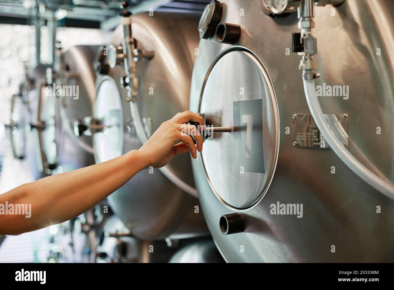 La main mâle ferme la trappe du réservoir de brasserie Banque D'Images
