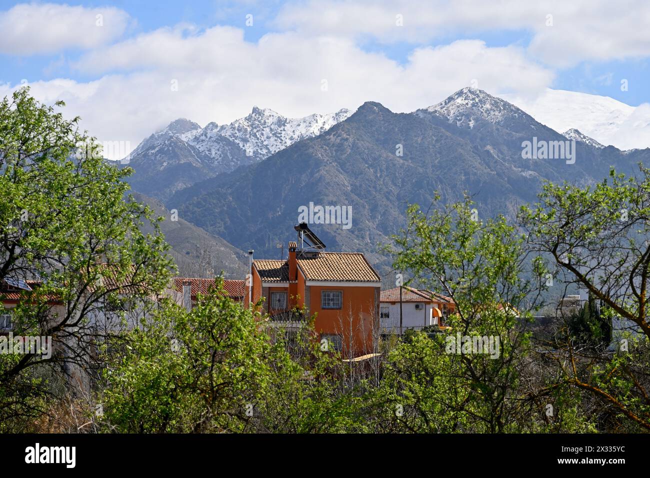 Petite banlieue, Dílar, de Grenade avec vue sur les maisons aux sommets enneigés des montagnes de la Sierra Nevada derrière, Grenade, Espagne Banque D'Images