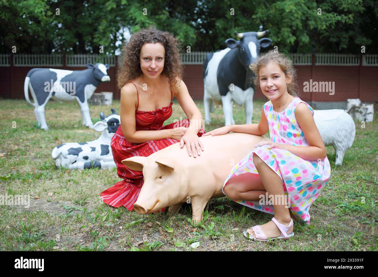 MOSCOU - 13 août 2014 : mère et fille (avec autorisations de modèle) près de jardin sculptures porc et trois vaches sur le territoire du Collège de l'hospitalité Banque D'Images
