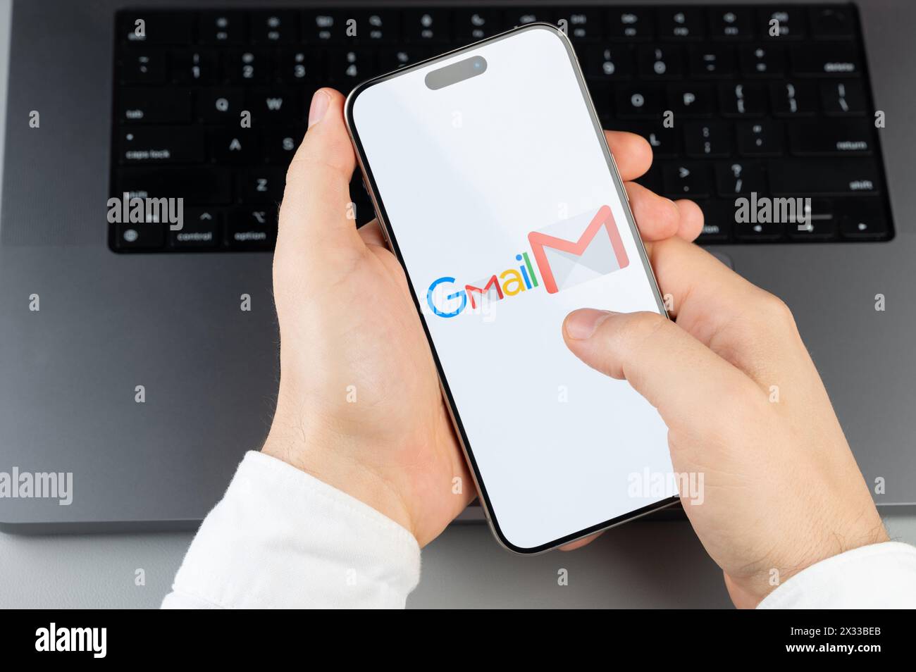 New York, États-Unis - 6 avril 2024 : populaire application mobile Gmail sur l'écran de smartphone dans les mains sur fond de clavier d'ordinateur portable Banque D'Images