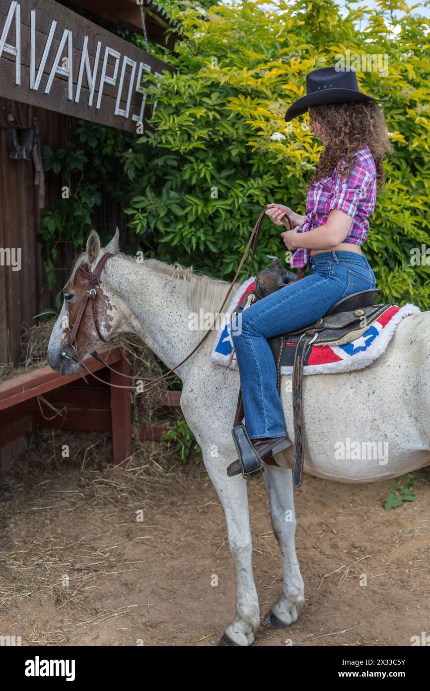 femme cow-boy dans un chapeau sur un cheval Banque D'Images