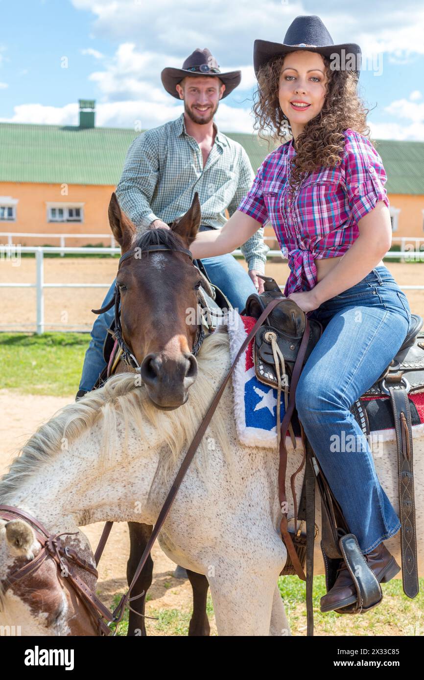 couple de cow-boys sur embrasser les chevaux Banque D'Images