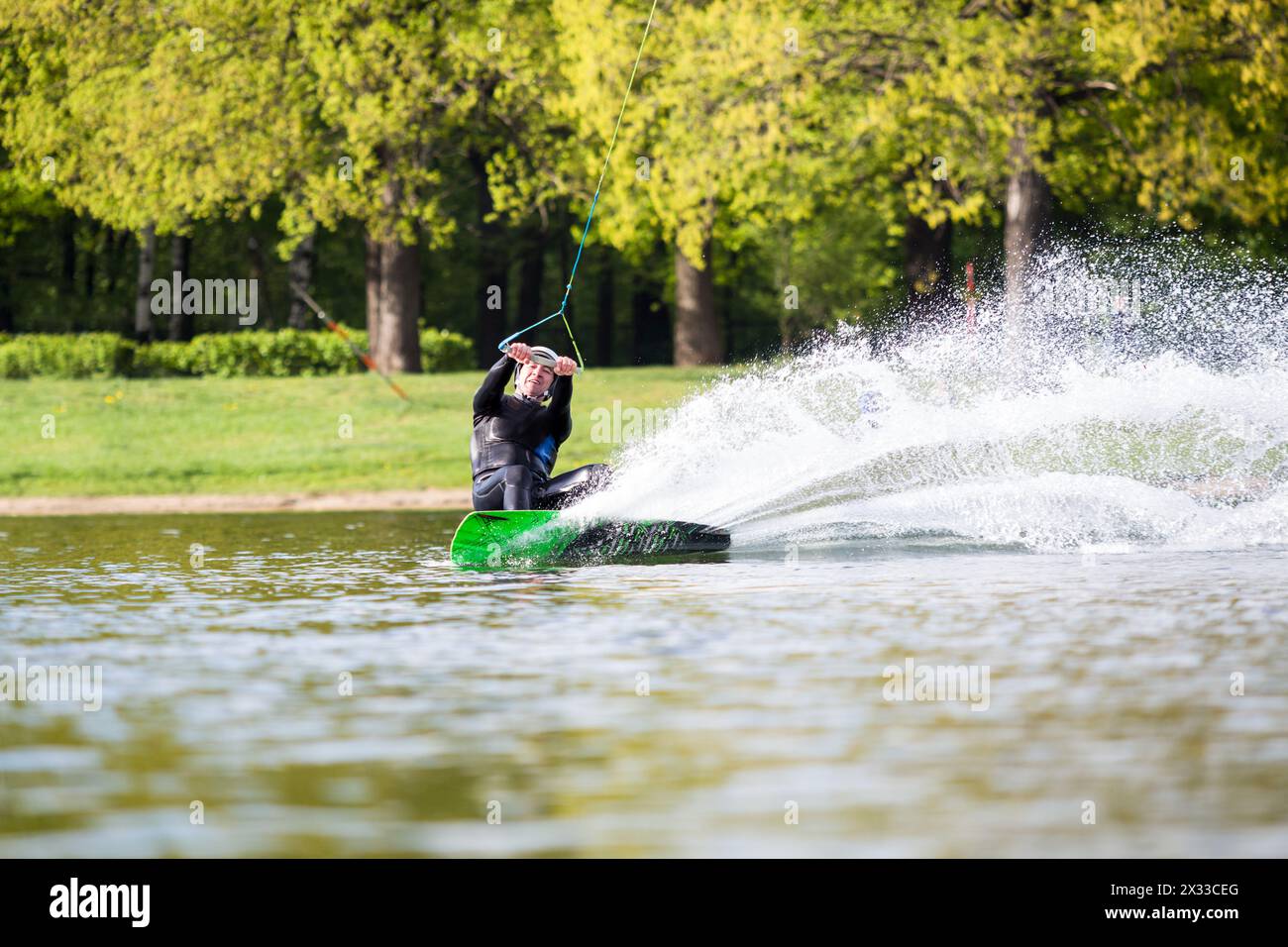 Wakeboarder masculin dans un jet sur l'étang dans le parc Banque D'Images