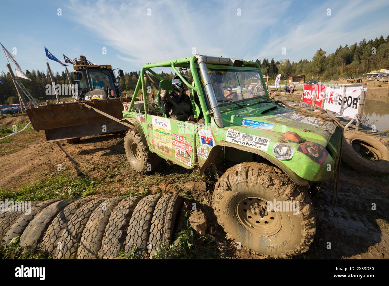 RUSSIE, PUSHKINO – 20 septembre, 2014 : le bulldozer tire hors route d'un étang sale sur Rainforest Challenge Russie automne 2014 PRO-X. Banque D'Images