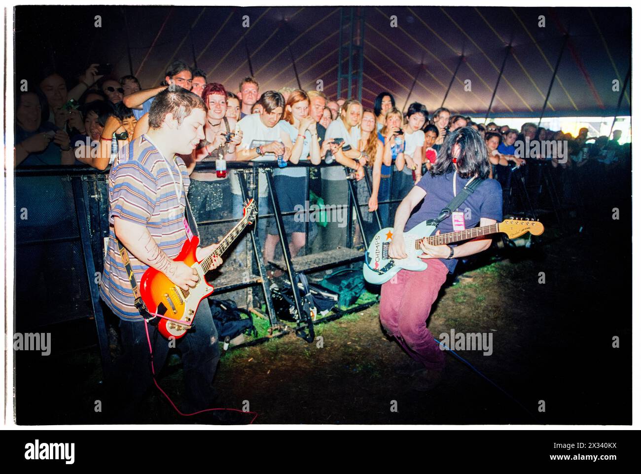 MOGWAI, DÉBUT DE CARRIÈRE, CONCERT DE 1997 : un jeune Stuart Braithwaite et John Cummings de Mogwai jouant devant la barrière de la foule dans la fosse sur la scène Melody Maker au Reading Festival, Reading, Royaume-Uni le 24 août 1997. Photo : Rob Watkins. INFO : Mogwai, un groupe de post-rock écossais formé en 1995, hypnotisse les auditeurs avec leurs paysages sonores expansifs et leurs instrumentaux émouvants. Connue pour ses compositions dynamiques et ses performances live puissantes, sa musique évoque une palette d’émotions, de l’introspection à l’euphorie. Banque D'Images