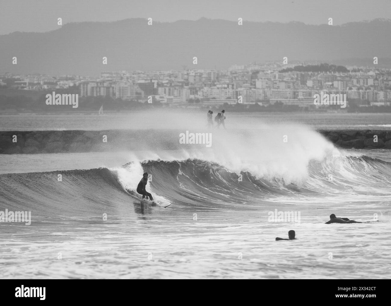 Lisbonne, Lissabon, 24.03.2024 : TravelPictures Lisbonne, Surfers attrapent habilement les vagues sur la Costa da Caparica avec une vue sur la ville. Banque D'Images