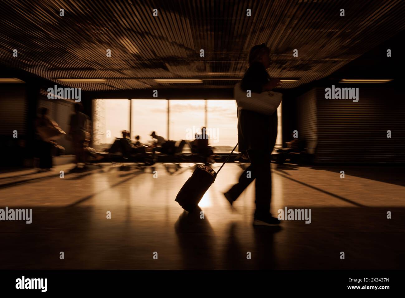 Les gens dans un terminal d'aéroport, marchant avec des bagages et assis, attendant leur heure de départ, mouvement flou shot. Concepts de voyage et de transport. Banque D'Images