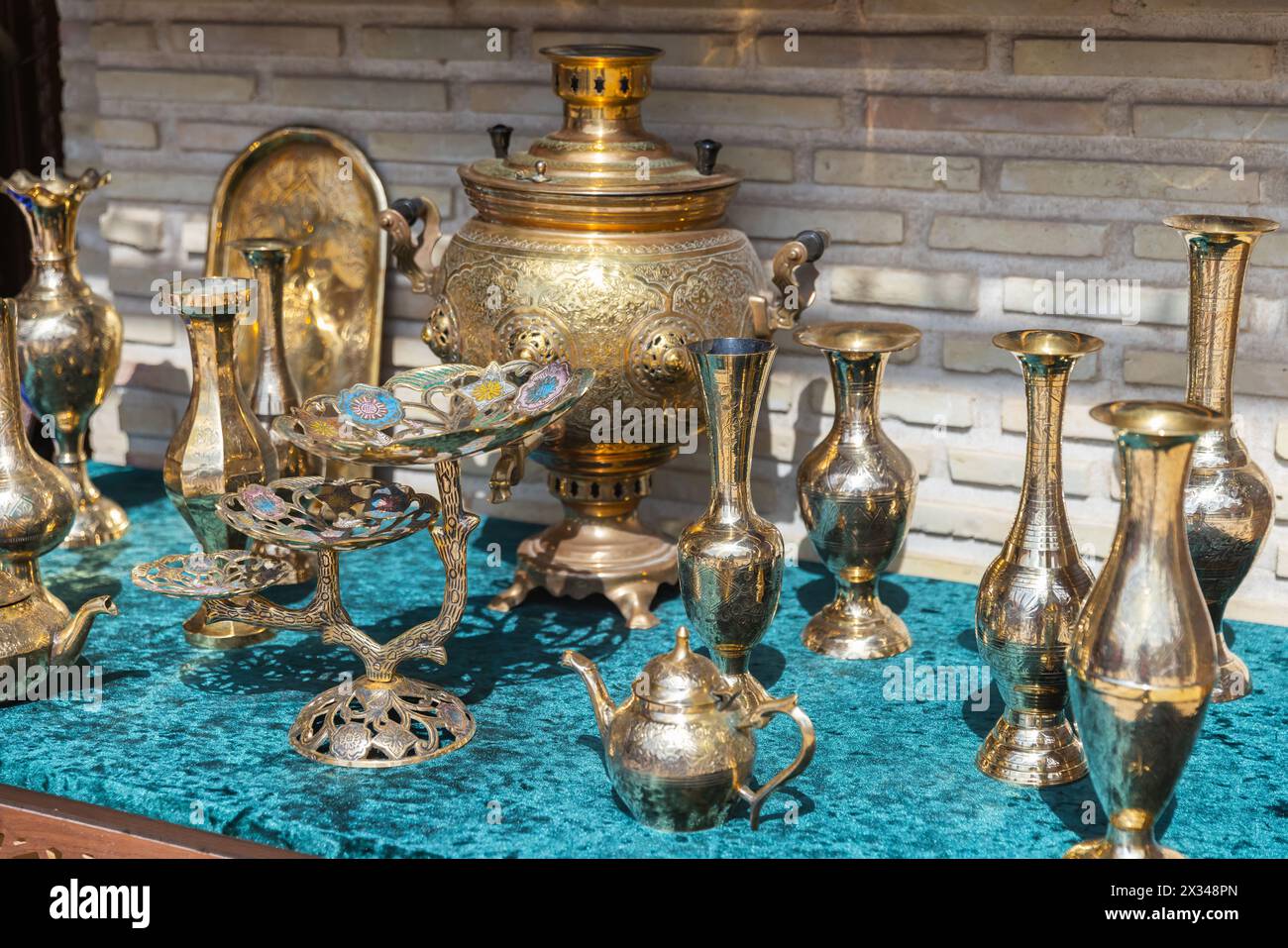 Des vases de luxe et d'autres plats en laiton avec des motifs en relief se tiennent sur le comptoir d'un bazar de rue à Boukhara Banque D'Images