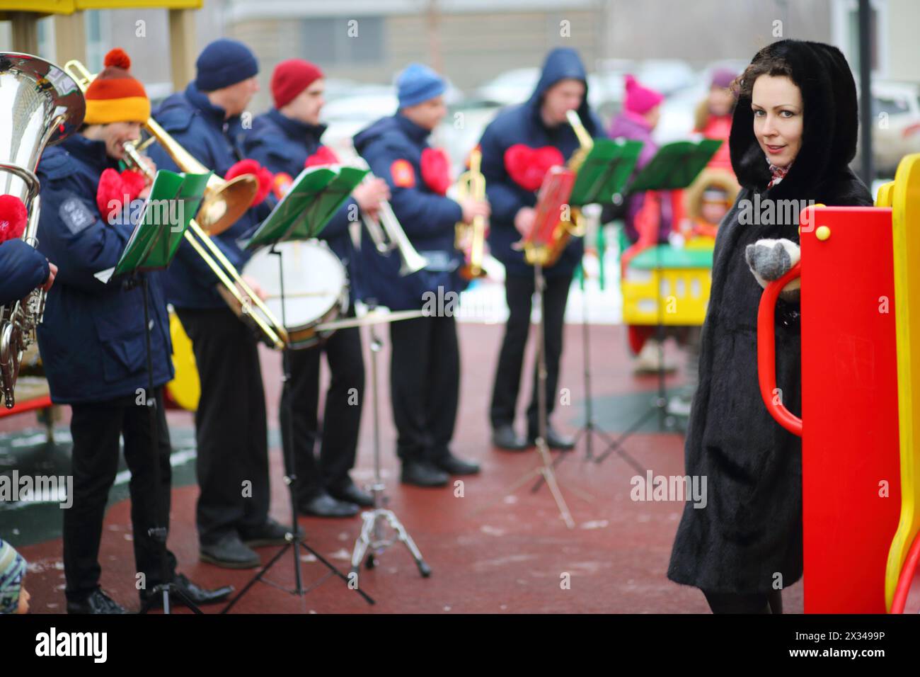 Brass band de six musiciens jouent sur le terrain de jeu et les femmes posent le jour d'hiver, se concentrer sur la femme Banque D'Images