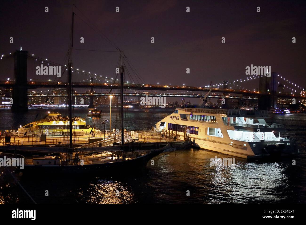 NEW YORK, États-Unis - 07 septembre 2014 : jetée avec bateau et bateau-taxi devant le lumineux Night Bridge à New York Banque D'Images